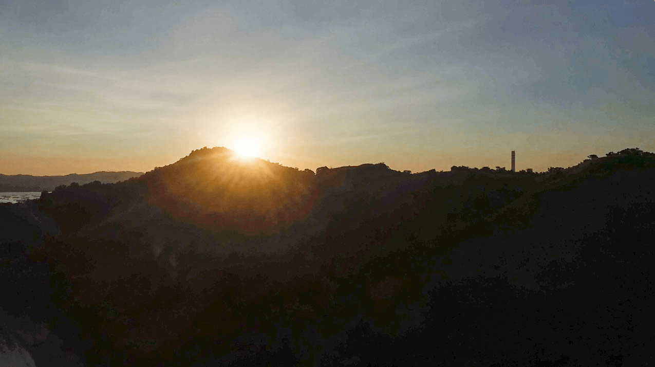 drone photo of sunset behind mountain at cabalitian island in pangasinan province philippines